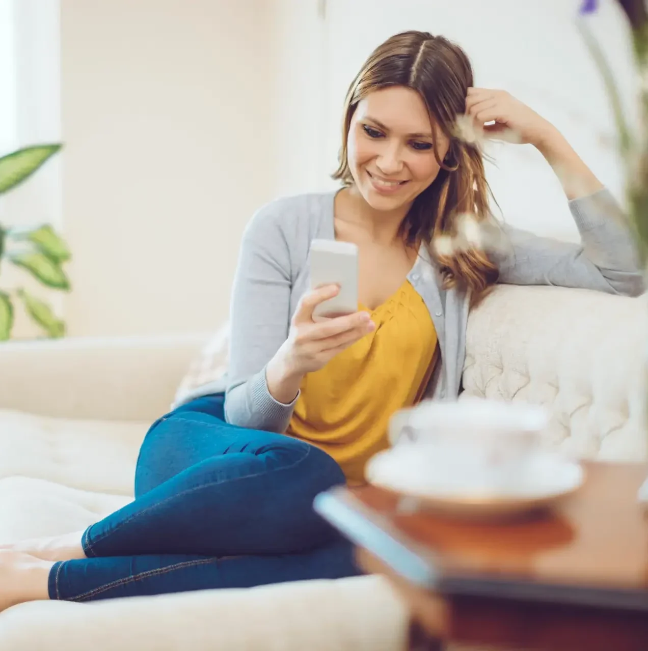 210409_Frau-mit-Handy-in-Hand-auf-Sofa